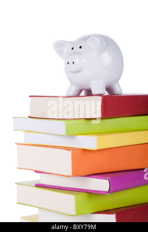 Tirelire sur une pile de livres colorés (isolé sur blanc) Banque D'Images