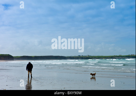 Un homme et son chien Sheltie, traverser la plage, flâner Corgi à Spanish Point, comté de Clare, sur la côte ouest de l'Irlande Banque D'Images