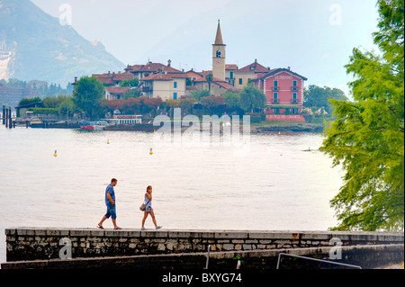 Couple en train de marcher sur l'Isola Bella avec Isola dei Pescatori dans le lointain Lago Maggiore Italie Banque D'Images