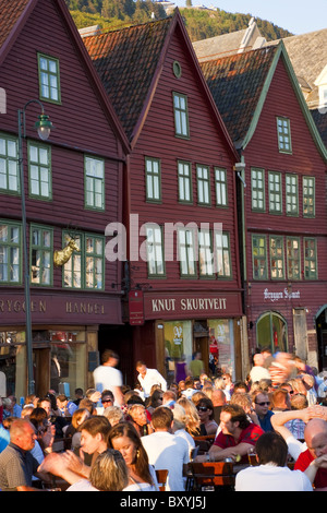 Les gens assis à trottoir bars/cafés, Bryggen, le quartier médiéval de Bergen, Hordaland, Norvège Banque D'Images