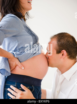 Jeune homme embrassant le ventre de femme enceinte Banque D'Images