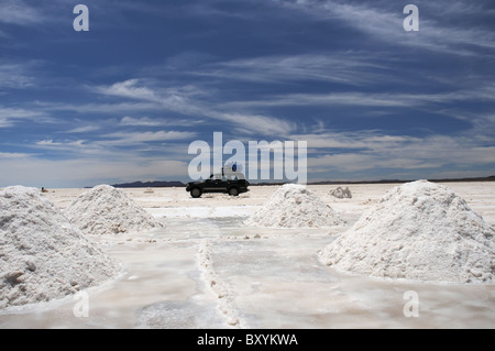 Un véhicule traversant le Salar de Uyuni entre les pieux de sel déterrés et prêt pour la purification Banque D'Images