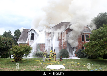 Les pompiers se relaient pour éteindre l'incendie d'une maison dans la région de Charlottesville, Virginia. Banque D'Images