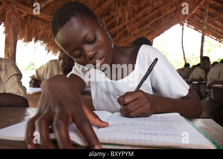 Un étudiant africain en études des femmes son toit de chaume de classe en milieu rural en Afrique. Banque D'Images