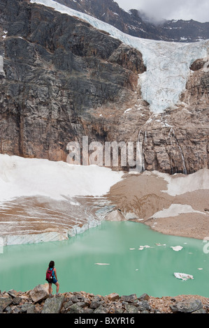 Hispanic woman hiking entendre lac glaciaire Banque D'Images