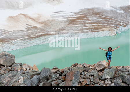 Hispanic woman hiking entendre lac glaciaire Banque D'Images