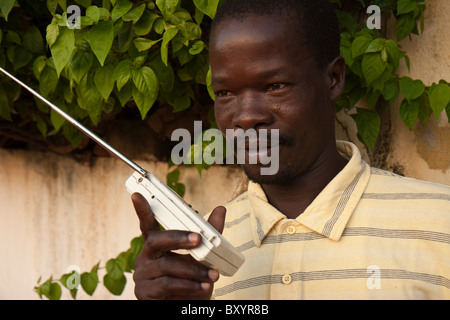 Un homme en Afrique de l'est à l'écoute d'une radio. Banque D'Images