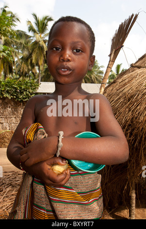 Un jeune garçon dont le village d'Afrique ont participé à un projet générateur de revenu pour améliorer la pauvreté rurale. Banque D'Images