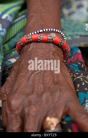 Une vieille femme portant un bracelet de poignet fait maison. La femme a participé à un projet générateur de revenu par une ONG. Banque D'Images