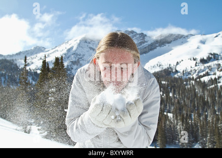 Girl blowing snow in mountains Banque D'Images