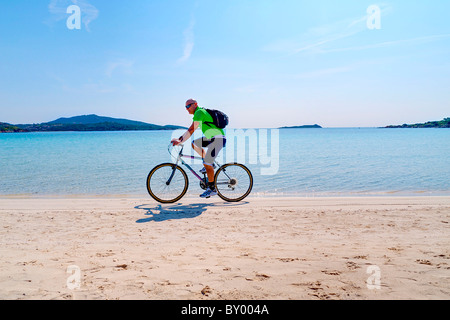 Man riding bicycle sur la plage Banque D'Images