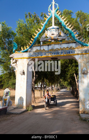 Décoré archway et farmer riding a moto remorque - Province de Kandal, Cambodge Banque D'Images