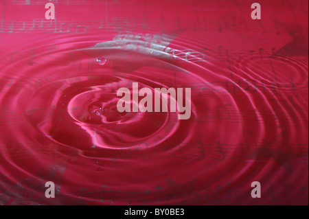 Une goutte d'eau tombe dans une piscine avec des notes de musique en toile de fond Banque D'Images