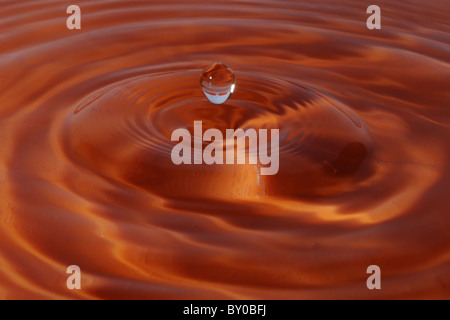 Une goutte d'eau tombe sur une superbe piscine ridée Banque D'Images
