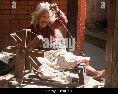 Vieille Femme filage de la laine dans l'ancienne ville de Bhaktapur à Katmandou, Népal Banque D'Images