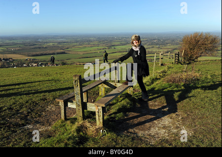 Woman climbing sur gate en marchant dans les South Downs Way à Devils Dyke près de Brighton Sussex UK Banque D'Images