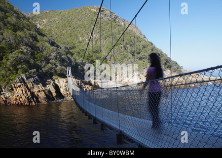 Femme marchant sur un pont suspendu dans le parc national de Tsitsikamma, tempêtes River, Eastern Cape, Afrique du Sud Banque D'Images