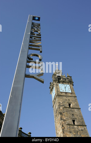 Ville de Glasgow, en Écosse. Le Merchant City signe à Glasgow Cross avec le péage clocher en arrière-plan. Banque D'Images