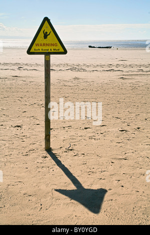 Avertissement de boue molle et triangle sur la plage près de Burnham on Sea avec le lointain naufrage du SS Nornen au bord de la mer Banque D'Images