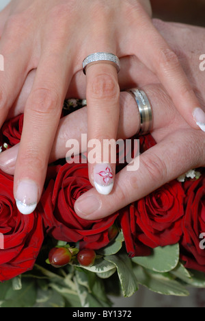 Mariée et le Marié mariage le jour de leur mariage en appui sur le bouquet de fleurs. Banque D'Images