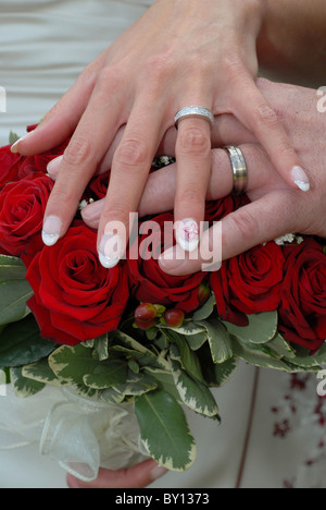 Mariée et le Marié mariage le jour de leur mariage en appui sur le bouquet de fleurs. Banque D'Images