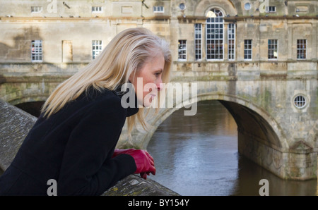 Une femme jouit de la vue sur la rivière Avon, baignoire. La célèbre Pultney Bridge est à l'arrière-plan. Banque D'Images