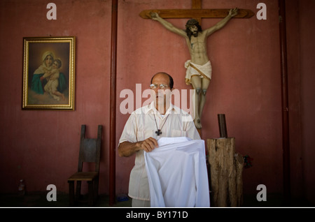Prêtre catholique, Alejandro Solalinde robes avant de célébrer une messe dans son abri pour les migrants à Ixtepec, Oaxaca, Mexique. Banque D'Images
