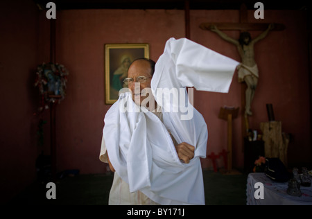 Prêtre catholique, Alejandro Solalinde robes avant de célébrer une messe dans son abri pour les migrants à Ixtepec, Oaxaca, Mexique. Banque D'Images
