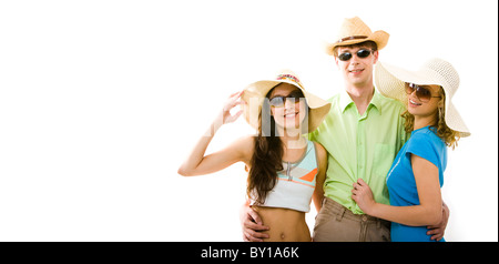 Portrait d'homme portant des lunettes noires debout entre deux filles à la mode des chapeaux et en les étreignant Banque D'Images