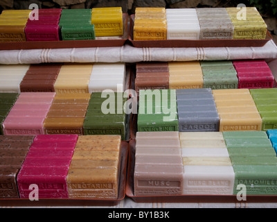Assortiment coloré de savons faits à la main disposés soigneusement dans un étal de marché en Provence. France Banque D'Images