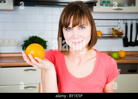 Jeune femme heureuse avec orange Banque D'Images