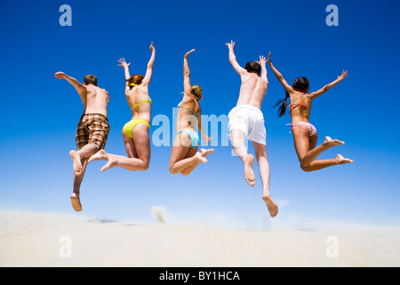 Portrait des jeunes de saut d'un dos à la plage Banque D'Images