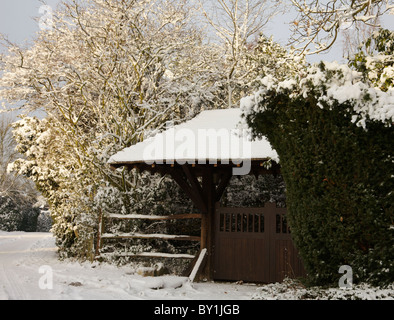 Une porte de jardin et haies couvertes de neige. Banque D'Images