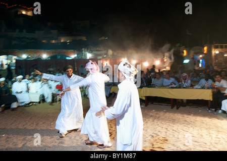 Les hommes participant à la célébration de mariages bédouins traditionnels de la danse comme vous regardez. El Tur, péninsule du Sinaï, Égypte Banque D'Images
