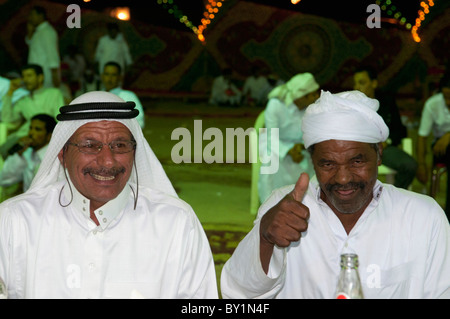 Cheikh bédouin célèbre avec l'invité lors de la célébration de mariages traditionnels du fils. El Tur, péninsule du Sinaï, Égypte Banque D'Images