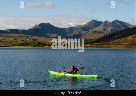 UK, au nord du Pays de Galles, Snowdonia. Un kayakiste sur Llyn Mymbyr avec le le Snowdon Horseshoe derrière. Banque D'Images