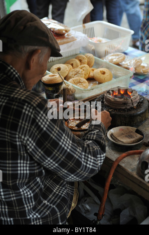 Vieux homme japonais la préparation de pâte dans un mode traditionnel à Sanja Matsuri, Asakusa, Tokyo, Japon Banque D'Images