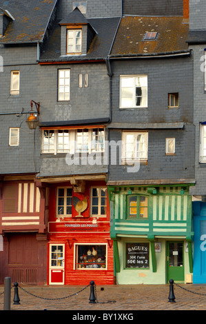 Harbour verso boutiques avec un vieux couple à la recherche de la fenêtre avec les bras autour de l'autre. Honfleur, Normandie, France. Banque D'Images