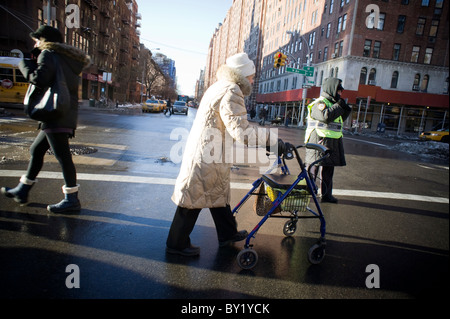 Une vieille femme traverse une intersection dangereuse dans le quartier de Chelsea à New York Banque D'Images