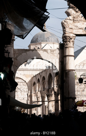 Une foule de gens marchant le long des murs de la mosquée Omeyyade et des ruines romaines anciennes du Temple de Jupiter, la vieille ville de Damas, Syrie. Banque D'Images