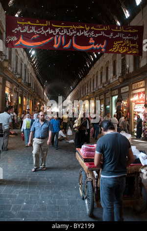 Promenade à travers les shoppers syrien occupé et encombré al Hamidiyah, marché typique d'un souk du Moyen Orient dans la vieille ville de Damas, en Syrie. Banque D'Images