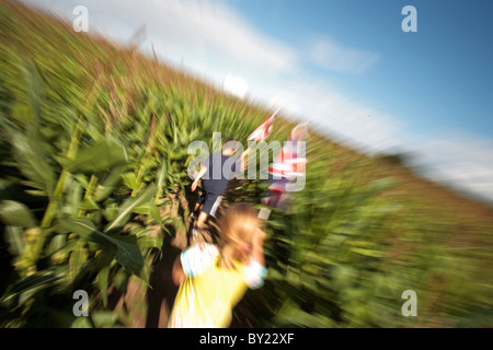 Forêt nationale ; Angleterre ; Leicestershire. Les enfants à la découverte de la Forêt Nationale de Labyrinthe de maïs, holding flags au cas où ils se Banque D'Images