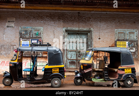 L'Inde, Cochin. Tuk Tuks garé contre un vieux mur dans Cochin. Banque D'Images