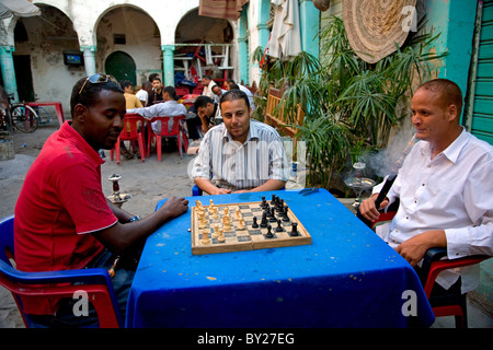Tripoli (Libye) ; l'homme tuer le temps en jouant aux cartes, jeux en carton et fumer la chicha dans la cour d'un '13' qui funduq Banque D'Images