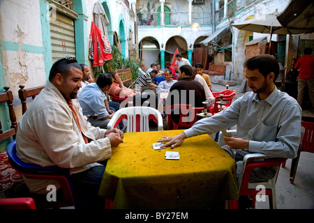 Tripoli (Libye) ; l'homme tuer le temps en jouant aux cartes, jeux en carton et fumer la chicha dans la cour d'un '13' qui funduq Banque D'Images