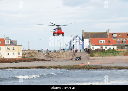 L'atterrissage de l'hélicoptère de recherche et sauvetage sur une plage à North Berwick, en Écosse. Le site est marqué par les torches fixées par les garde-côtes. Banque D'Images