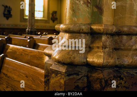 Faux marbre peint à la main de la base du pied est éclairé par le soleil de l'après-midi dans l'église Saint Stanislas Kostka dans Adams, MA. Banque D'Images