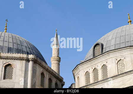 ISTANBUL, Turquie / Türkiye — dômes d'une mosquée à Istanbul, avec un minaret culminant entre eux contre un ciel bleu clair. Banque D'Images