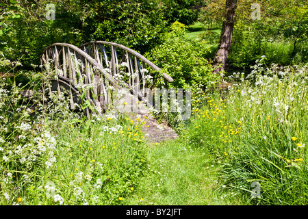 Une passerelle rustique de charme dans un coin tranquille d'un pays anglais jardin en été Banque D'Images