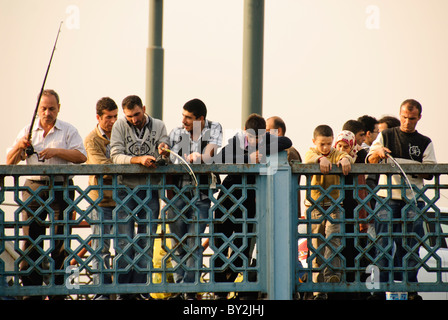 ISTANBUL, Turquie — les pêcheurs locaux bordent les balustrades du pont historique de Galata qui enjambe la Corne d'Or. Le pont, qui relie Eminonu à Karakoy, est un lieu de pêche populaire depuis des générations. Des dizaines de pêcheurs se rassemblent régulièrement le long du niveau supérieur du pont pour jeter leurs lignes dans les eaux en contrebas. Banque D'Images